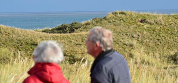To ældre mennesker der går en tur ved kysten